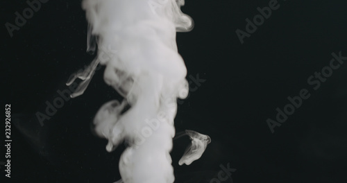 closeup vapor stream rises from bottom center on black background