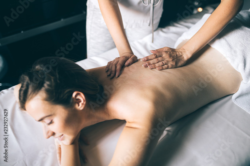 Young and healthy woman in spa salon. Traditional Swedish massage therapy