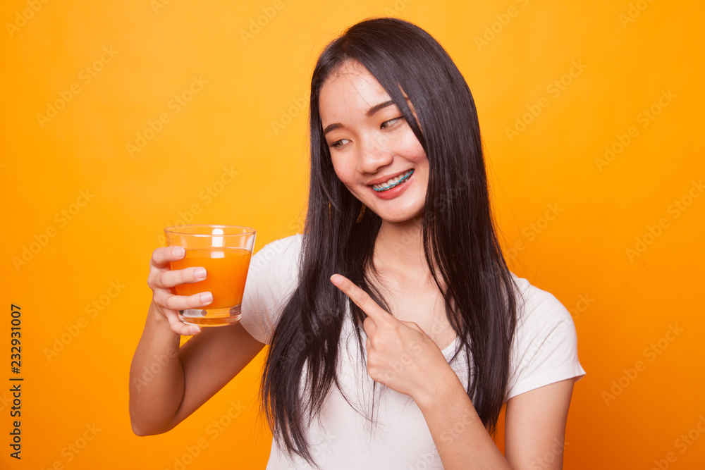 Young Asian woman point to orange juice. Young Asian woman point to orange juice.