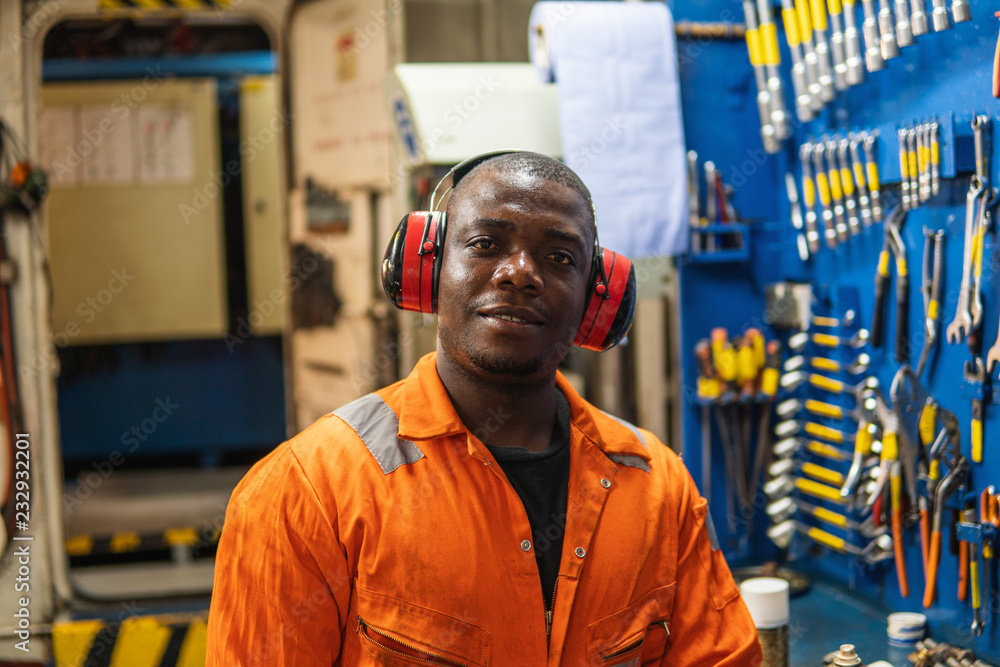 African marine engineer officer in engine control room ECR. He works in workshop with equipment African marine engineer officer in engine control room ECR. He works in workshop with equipment