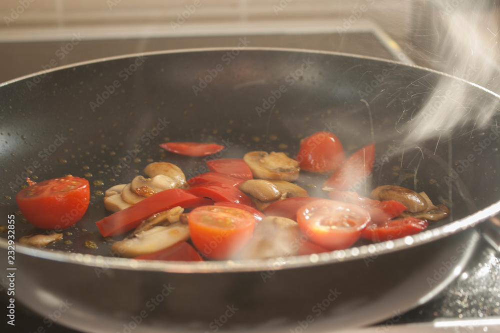Mushrooms & Tomatos sizzling in a frying pan Mushrooms & Tomatos sizzling in a frying pan