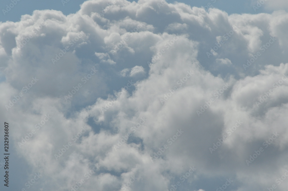 Obraz premium Puffy clouds against a blue sky. Beautiful, sunny weather.