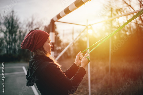 Young woman exercising with resistance band on the playground