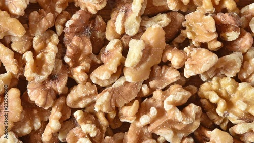 A bowl of chopped walnuts and a cutting board