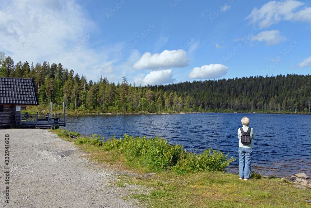 Touristin schaut auf den Kierats See bei Jokkmokk