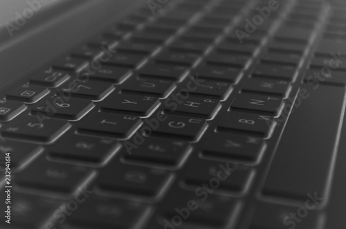 Black computer keyboard close-up. Computer manipulator, laptop keyboard. Information technology and business, dark background.