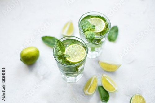 Summer refreshing cocktail mojito with lime and mint on white background.Slices of lime, mint, glass with ice cubes on white background.