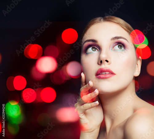Attractive female model woman with colorful makeup on glitter background