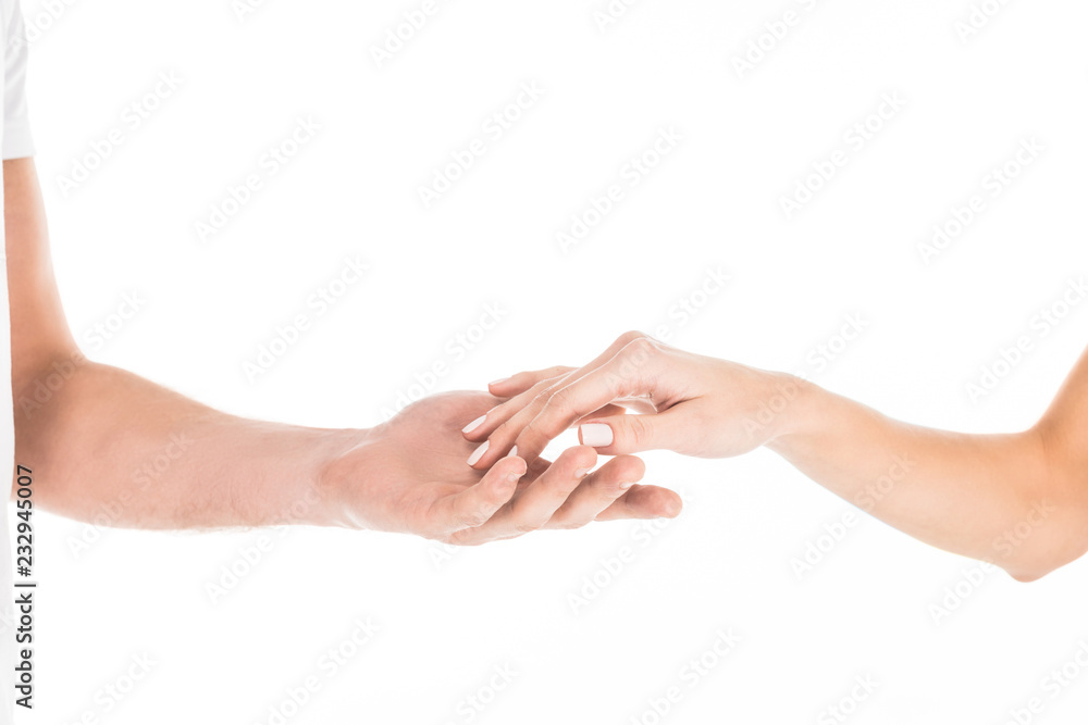 Partial view of people tenderly holding hands isolated on white