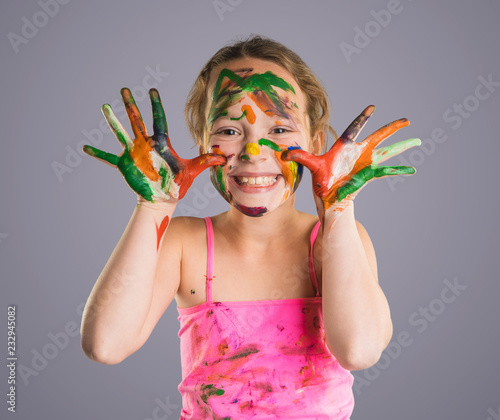 beautiful little girl with hands in the paint