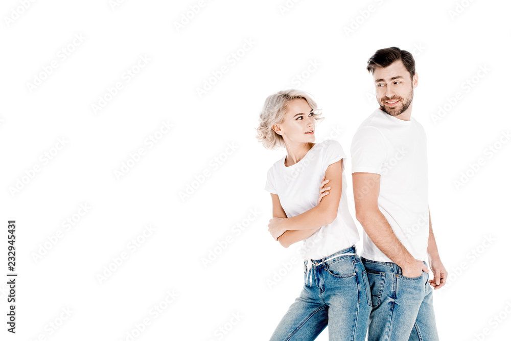 Wonderful couple standing back to back while smiling at each other isolated on white Wonderful couple standing back to back while smiling at each other isolated on white