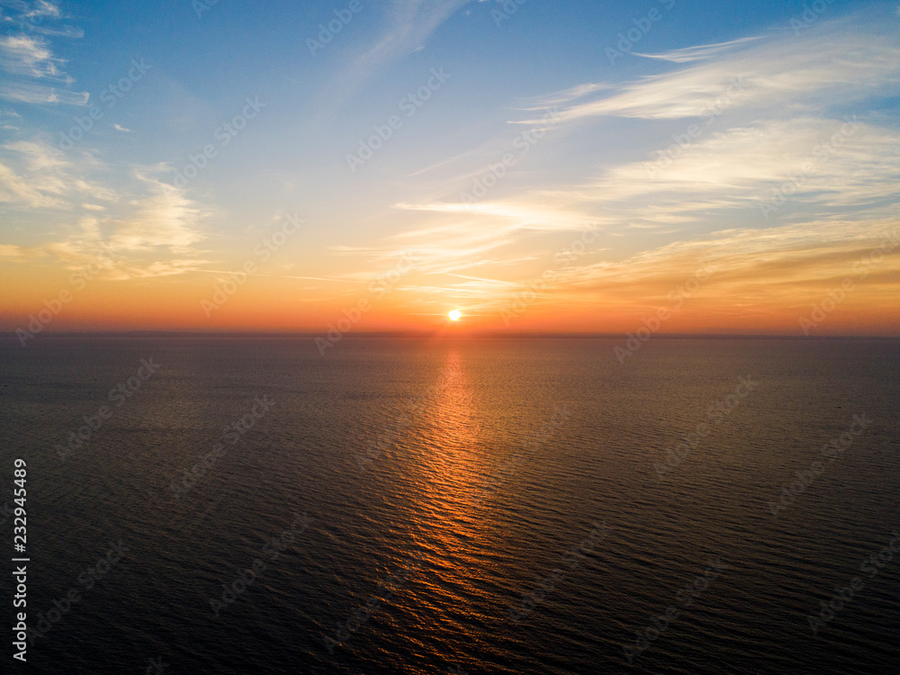 Aerial view of a Sunset sky background. Aerial Dramatic gold sunset sky with evening sky clouds over the sea. Stunning sky clouds in the sunset. Sky landscape. Aerial photography.