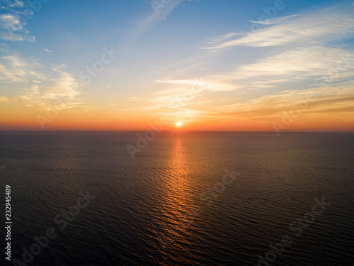 Aerial view of a Sunset sky background. Aerial Dramatic gold sunset sky with evening sky clouds over the sea. Stunning sky clouds in the sunset. Sky landscape. Aerial photography.