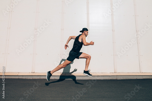 Runner man running fast in industrial city background