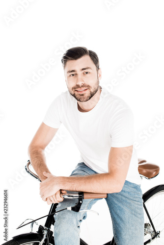 Handsome smiling young adult man riding bicycle isolated on white