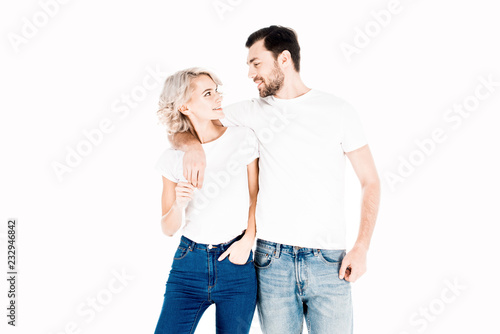 Happy smiling couple hugging while looking at each other isolated on white
