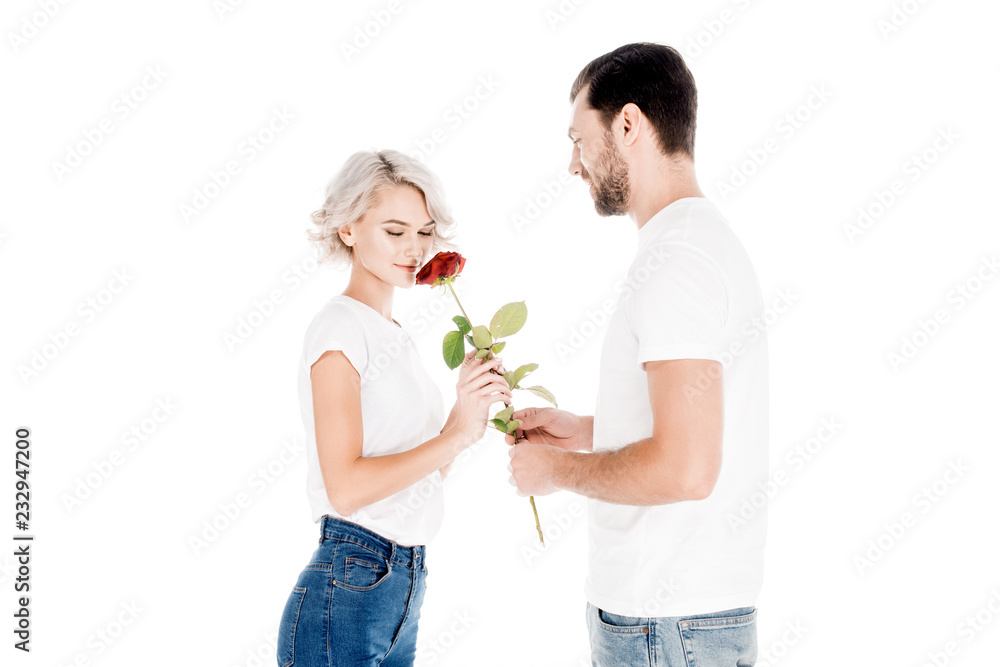 Handsome man giving red rose to beautiful blonde woman isolated on white Handsome man giving red rose to beautiful blonde woman isolated on white