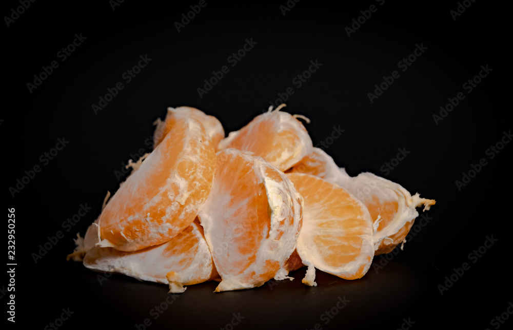 Half peeled mandarin on a black background close-up Half peeled mandarin on a black background close-up