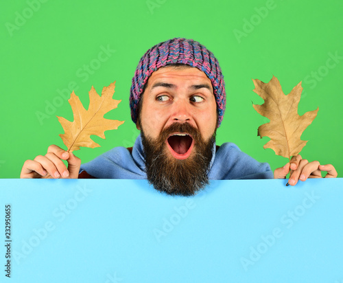 Hipster with beard and surprised face wears warm clothes