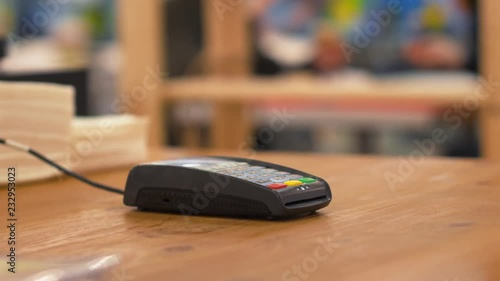 Woman tapping credit card on payment terminal.
