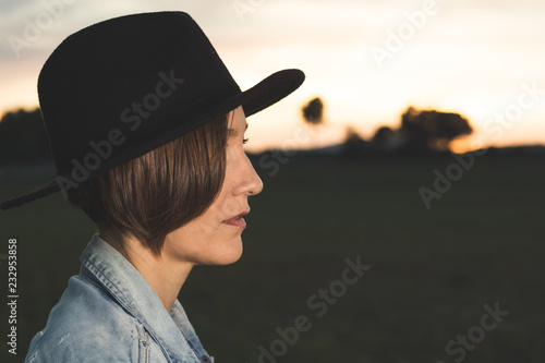 Portrait of a woman in a black hat in the country. Photo style social networks