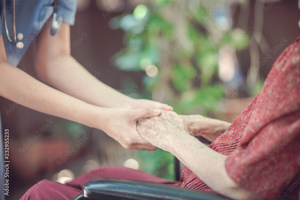 Hand of  eldery  woman with her caregiver at home. Home care or Elderly care concept.