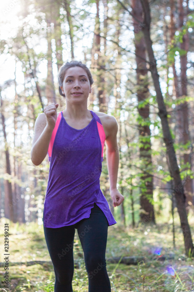 Young female runs in morning forest Young female runs in morning forest