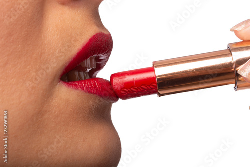 ragazza che applica il rossetto rosso sulle labbra  photo