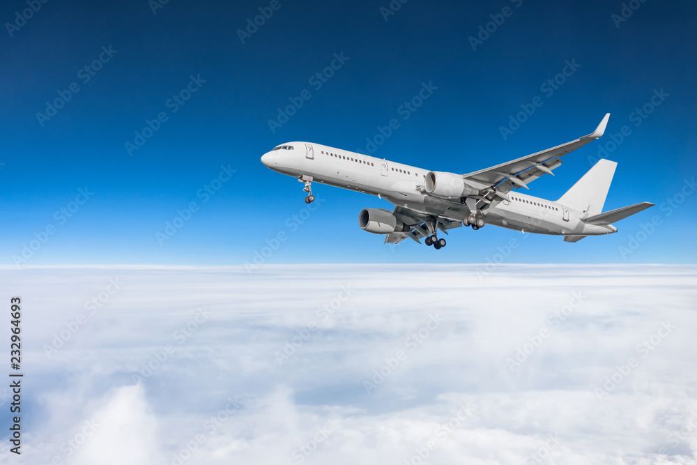 Passenger plane fly on a train above clouds and blue sky. Passenger plane fly on a train above clouds and blue sky.