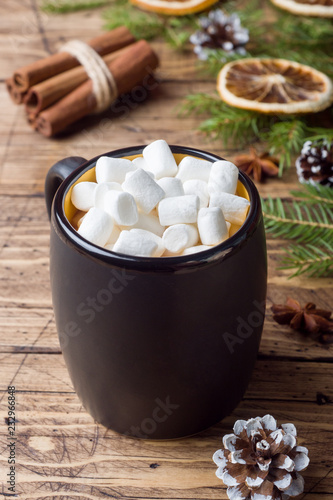 Hot chocolate with marshmallow cinnamon sticks, anise, nuts on wooden background, Christmas concept