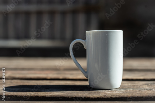Closeup of a Cup of black coffee on a wooden table outdoors