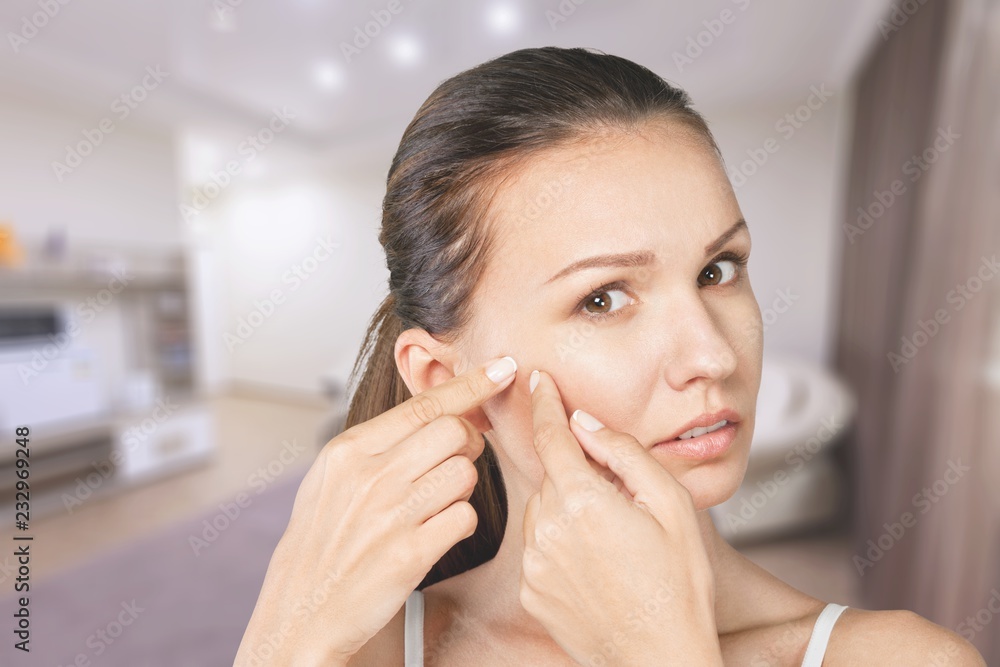 Portrait of young attractive woman touching her face and looking Portrait of young attractive woman touching her face and looking