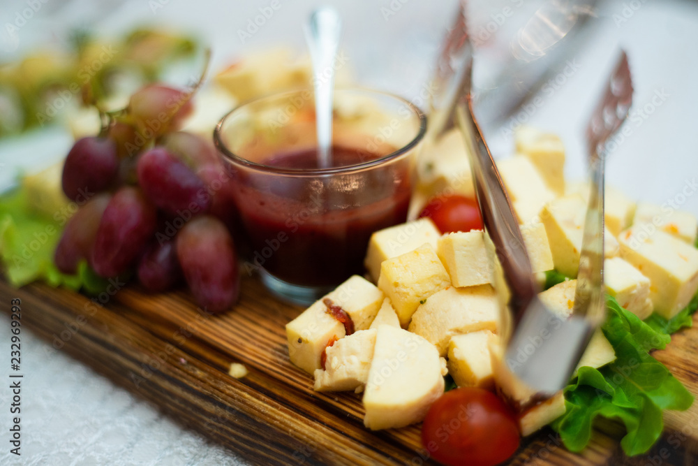 Cheese, grapes and sauce on a wooden Board