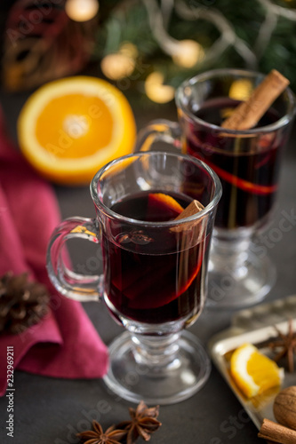 Mulled wine in glass with spices at dark background