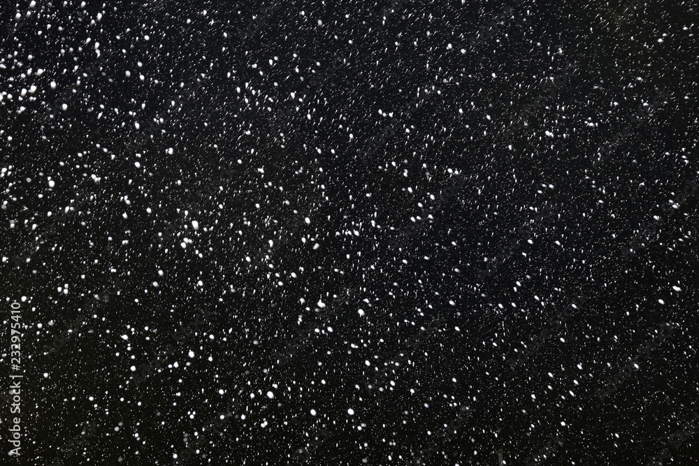 Real falling snow on a black background