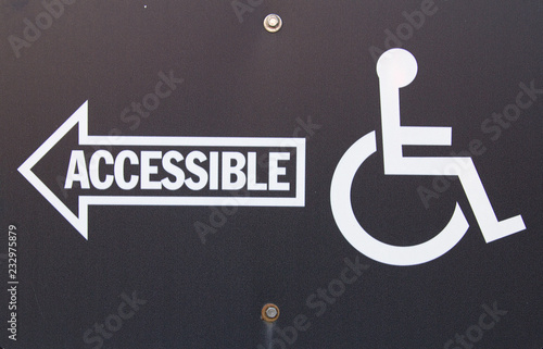 Handicapped Accessible Sign. Black sign with white writing and arrow pointing handicapped accessible entrance.  photo