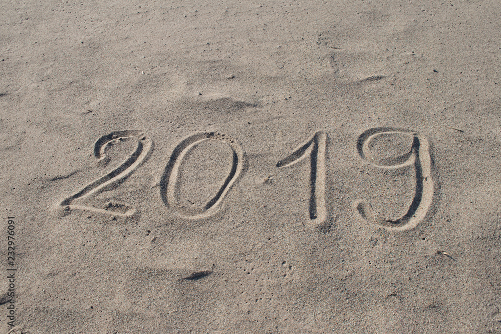 Fototapeta premium 2019 hand drawn on the sand. New Year is Coming or Holidays Catalog Abstract Background Design