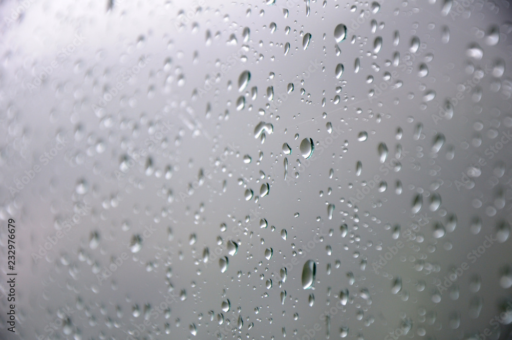 Drops of water on the glass. Rain. Part of the image is blurred. Drops of water on the glass. Rain. Part of the image is blurred.