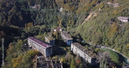 pictorial aerial view abandoned ghost town buildings at steep forestry hill foot shows slow nature restoration photo