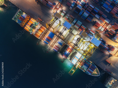 Aerial view container ship at sea port and working crane bridge loading container for logistics import export or transportation concept background.