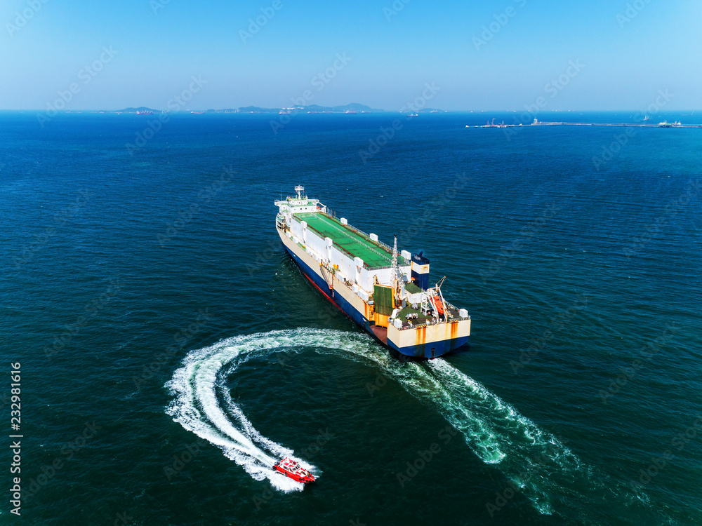 Aerial view Tug boats finish drag carry car ship or cargo ship to sea  for import  export or transportation concept background.