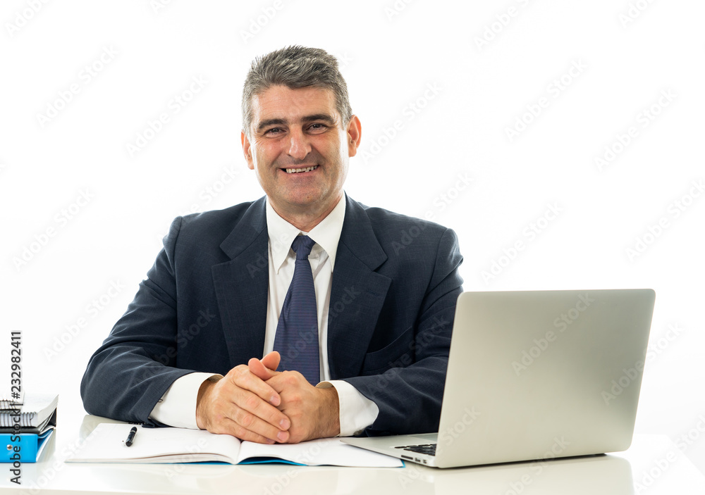 Attractive happy mature caucasian businessman working on laptop computer on desk at office Attractive happy mature caucasian businessman working on laptop computer on desk at office