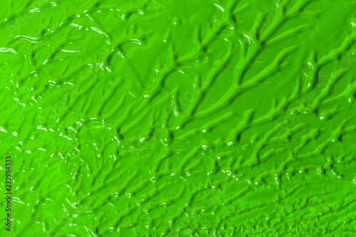 green stroke of the paint brush on white paper