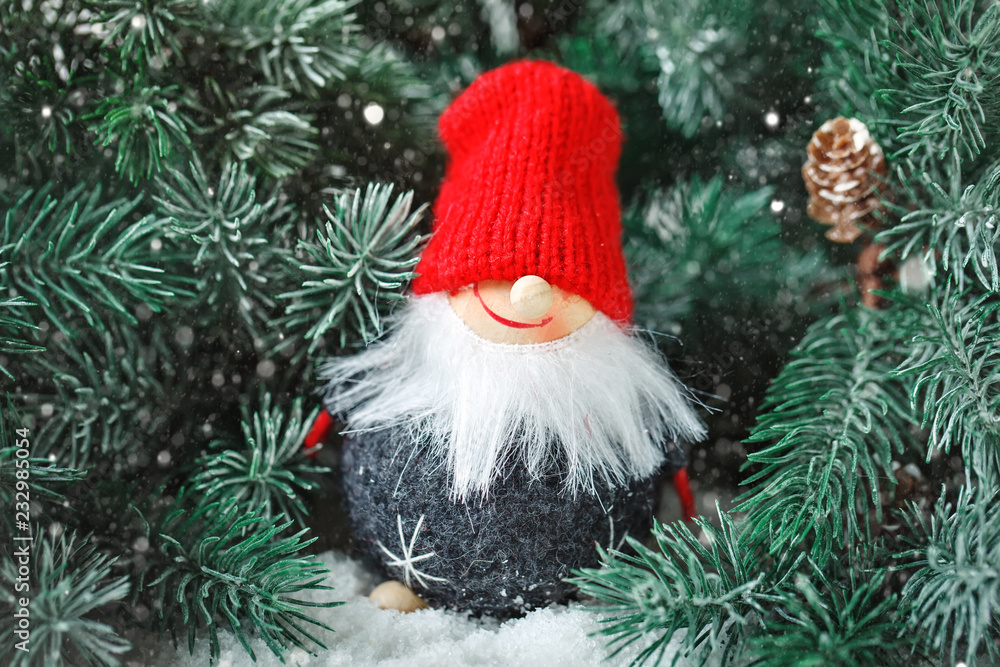 Merry Christmas and happy New year. Toy Santa in the branches of a spruce. Selective focus. Merry Christmas and happy New year. Toy Santa in the branches of a spruce. Selective focus.