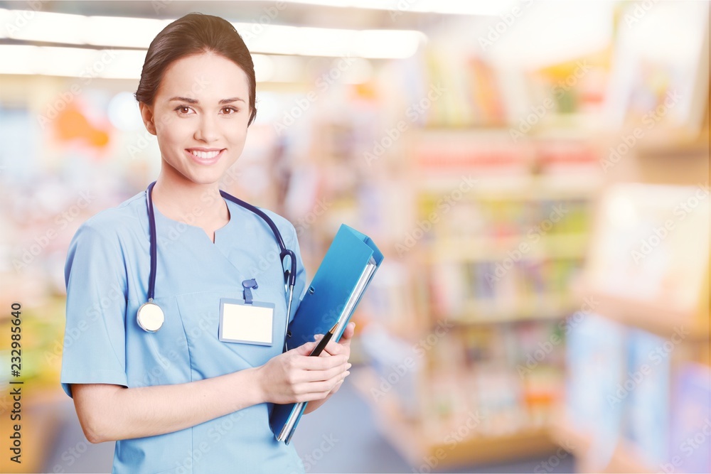 Attractive young female doctor with blurred hospital interior on Attractive young female doctor with blurred hospital interior on