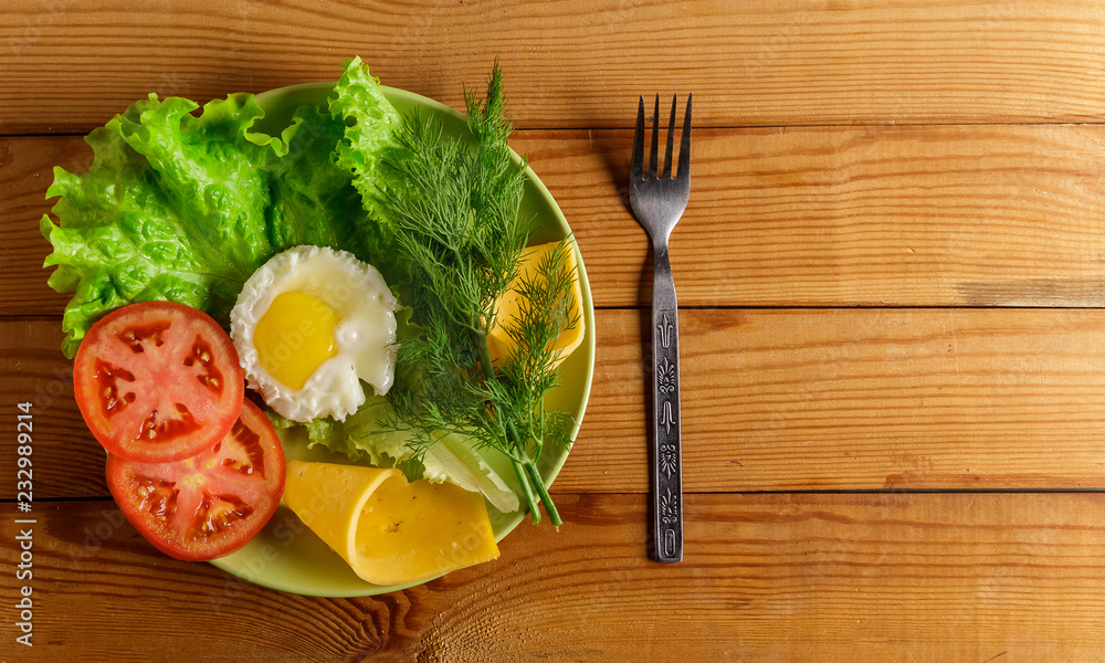Fried eggs, pieces of vegetables, bread and fork on the table. Fried eggs, pieces of vegetables, bread and fork on the table.