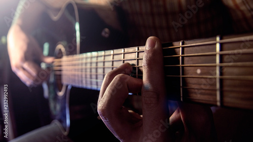 Guitar Playing. Man Playing Acoustic Guitar Closeup photo