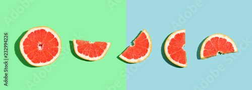 Fototapeta Naklejka Na Ścianę i Meble -  Halved fresh grapefruits on bright color background