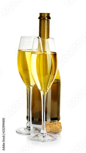 Two glasses of champagne on the background of brown bottles close-up isolated on a white.