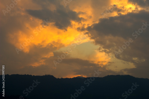 dark sunset sky with bright orange clouds against the black silhouettes of the mountains. mountain sunset. mountain dawn